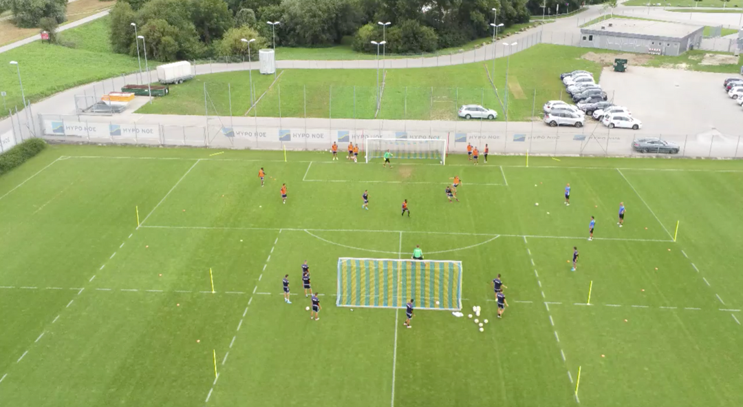 Auf dem Bild zu sehen ist Ist ein Fussballtraining von oben auf einem Fussballfeld