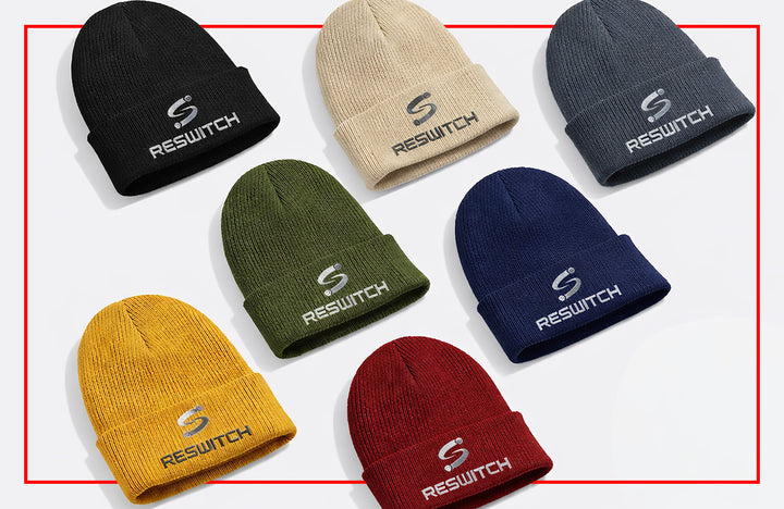 Acht Organic Cotton Beanie | Beechfield B50 Mützen von matchconcept UG - schwarz, beige, grau, grün, navy, gelb, rot und hellbraun - sind jeweils mit einem RESWITCH-Logo auf weißem Hintergrund mit rotem Rand abgebildet.
