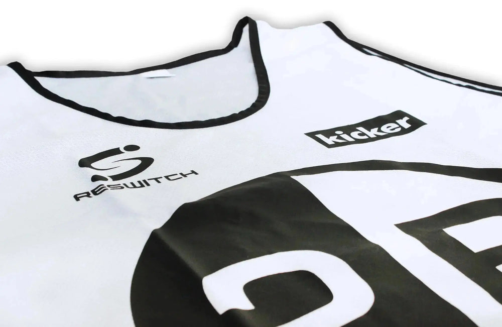 Eine Nahaufnahme eines weißen Sporttrikots mit schwarzem Rand und den Logos von matchconcept UG und kicker, eine auffällige Nummer auf der Vorderseite - ideal zur Kombination mit dem RESWITCH Pro-Coach Set oder anderen matchconcept UG Fußball-Essentials.