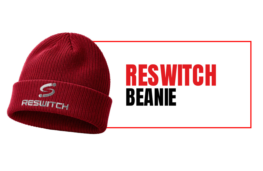 Rote Strickmütze aus Bio-Baumwolle von matchconcept UG (Beechfield B50) mit weißem RESWITCH-Logo und fettem "RESWITCH BEANIE"-Text auf weißem Hintergrund mit rotem Rand.